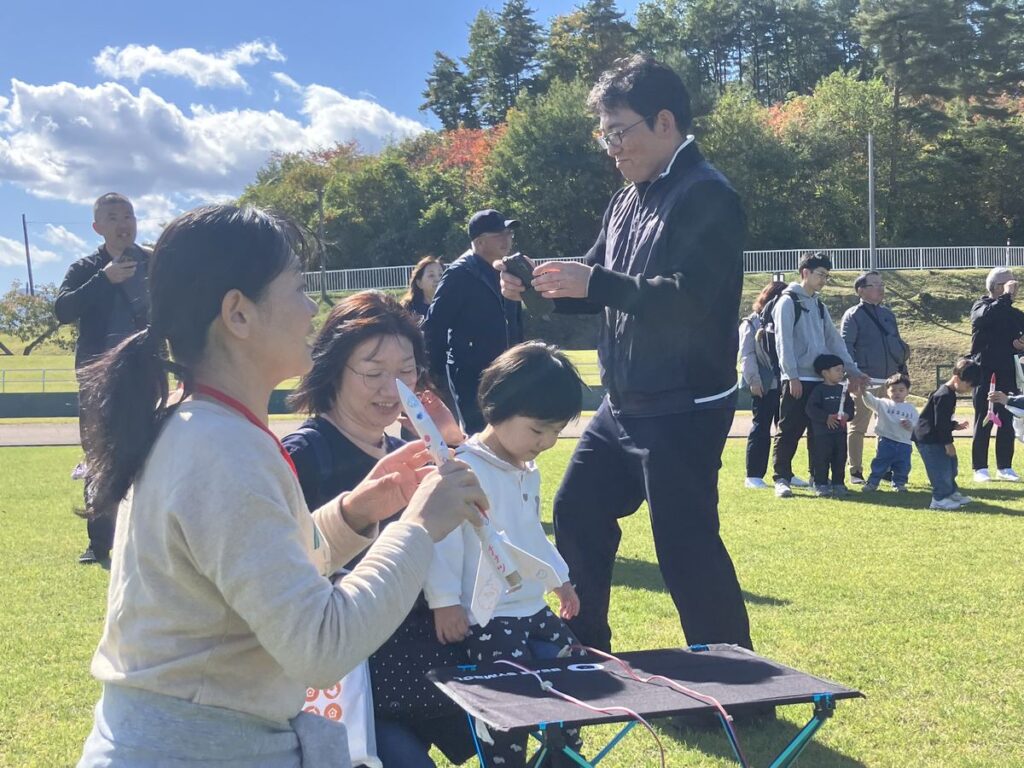 発射台の前で打ち上げの準備をする親子